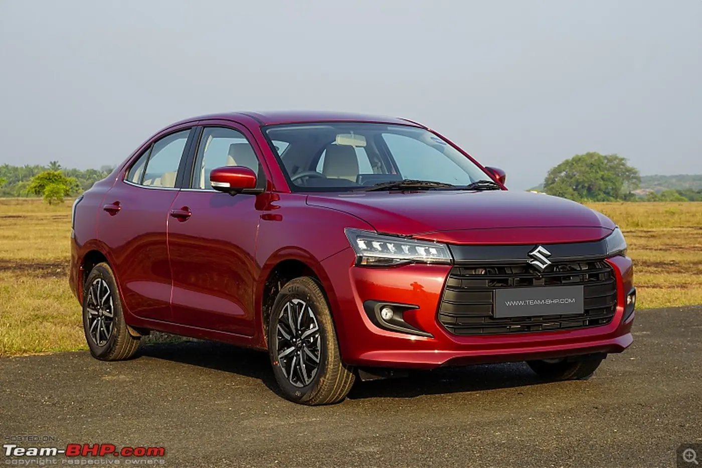 Red Maruti Swift Dzire city taxi on a road outside Mangaluru
